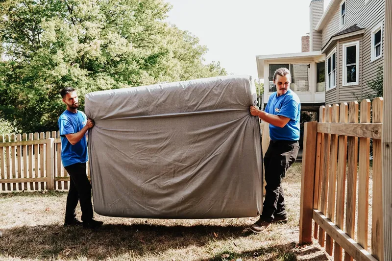 Two professional movers carrying furniture